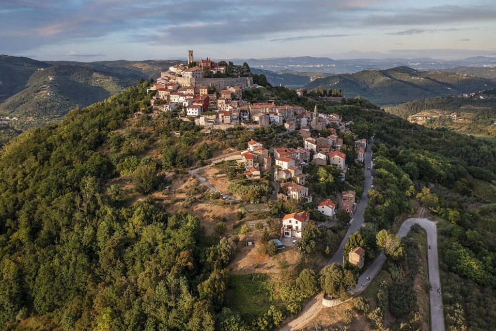 Aerial view of the hilltop walled town of Motovun surrounded by forested Istrian valley